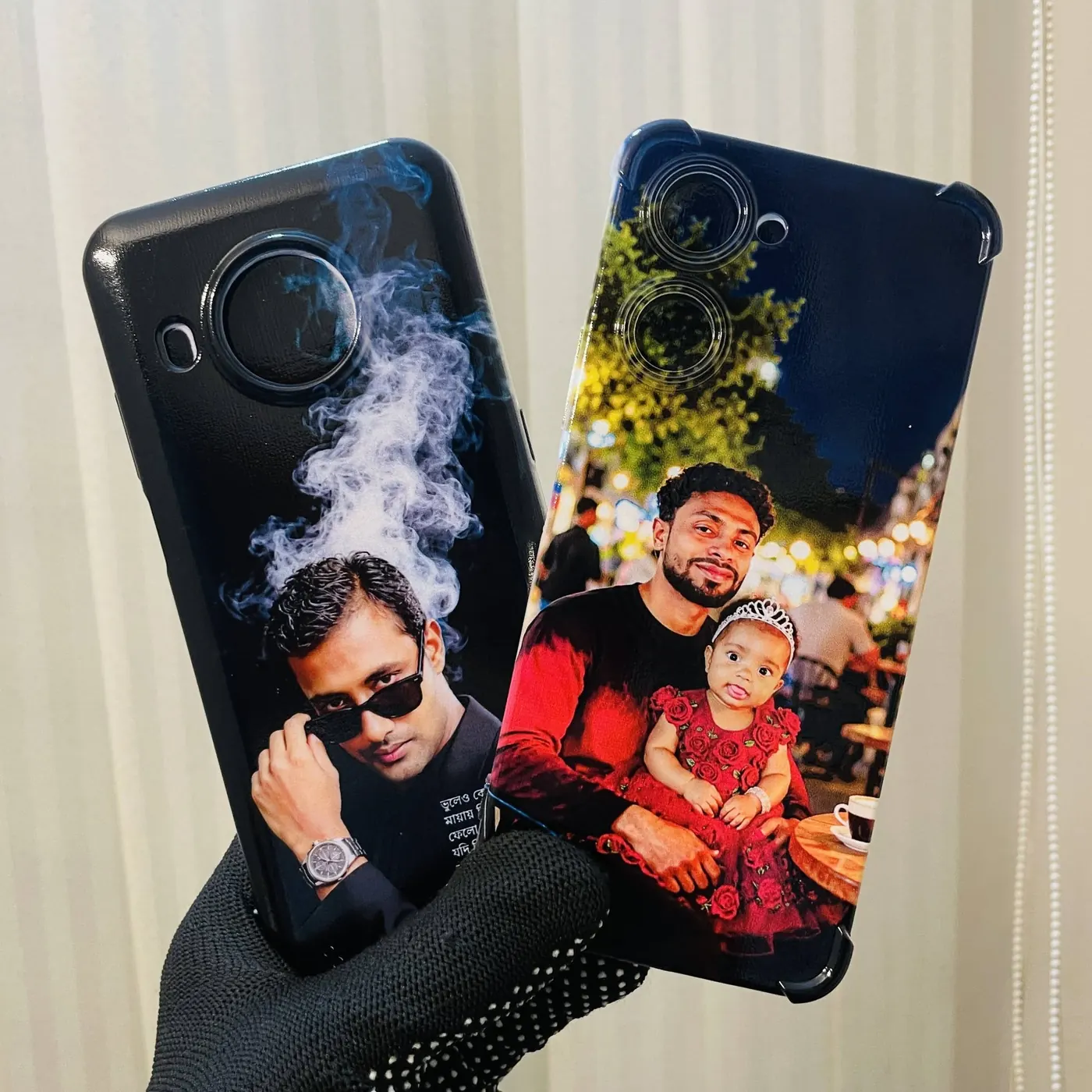 Two custom printed phone covers with customer photos, held up in the shop