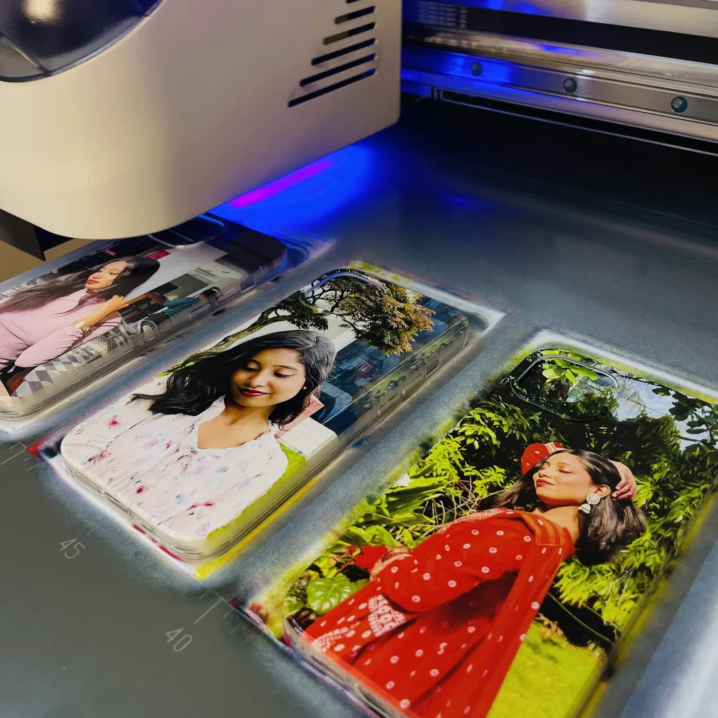Phone covers with customer photos on the UV printer bed